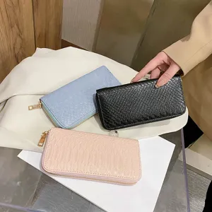 Detailed view of women's long wallets with embossed crocodile pattern in three colors