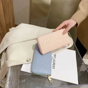 Close-up detail of stylish pink and blue crocodile textured long wallets for women