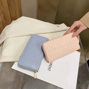 Close-up of stylish women's long wallets with blue and pink crocodile textured finish