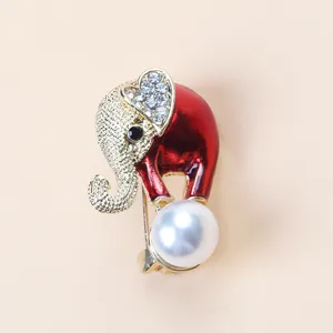 Detailed close-up of a red enamel elephant brooch with crystal ear and large white pearl.