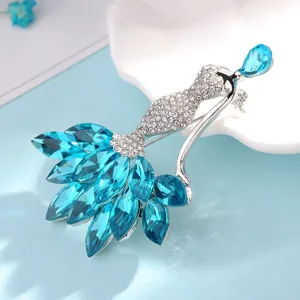 Detail shot of an elegant mermaid brooch with blue crystals on a soft blue background