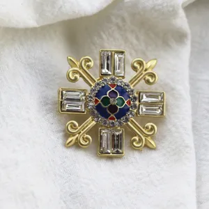 Detailed macro view of vintage matte gold Baroque brooch with enamel and crystals