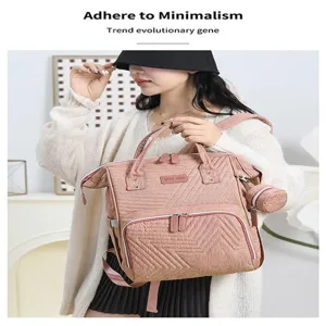 Pink quilted diaper backpack for mothers, large capacity multi-functional travel bag with dual shoulder straps.