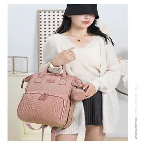 Multi-functional pink quilted diaper backpack for mothers with large capacity and stylish design.