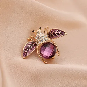 Detailed close-up of a purple crystal bee brooch with golden alloy and rhinestones