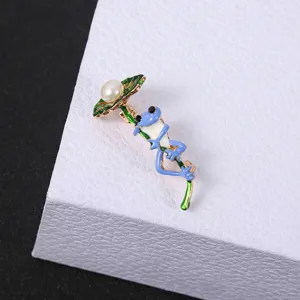 Creative cartoon frog brooch with blue enamel and pearl detail on green leaf design