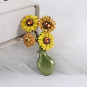 Close-up detail of a vintage style enamel sunflower vase brooch with amber centers