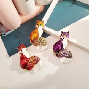 Dettaglio ravvicinato di spillette a volpe in smalto vintage con strass colorati brillanti