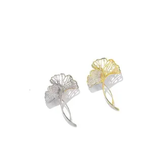 Elegant ginkgo leaf brooches with sparkling micro-set cubic zirconia in gold and silver.