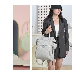 Grey quilted diaper backpack with multi-functional compartments and attached small pouch.