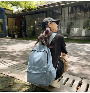 Lifestyle-Ansicht eines lässigen blauen Denim-Rucksacks für Reisen und Schule im Freien