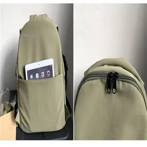 Detailed view of the front storage pocket and double zipper on green nylon backpack