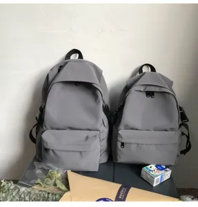 Comparison of two sizes of minimalist grey nylon water-resistant backpacks for students
