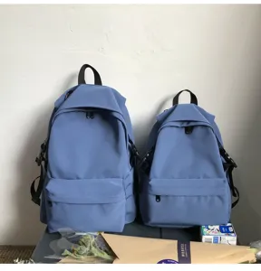 Minimalist blue nylon backpacks in two sizes side by side for comparison