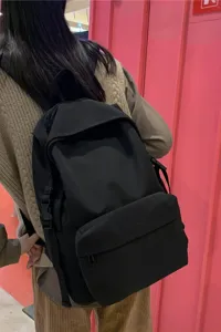 Back view of a minimalist black nylon backpack, waterproof and lightweight student bag