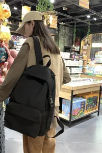 Detail of the lightweight black nylon backpack for students shown in a daily usage scene