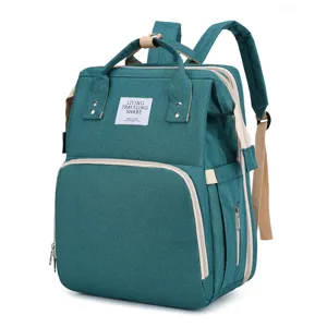Multifunktionaler blaugrüner Windelrucksack mit großer Kapazität und faltbarem Babybett.