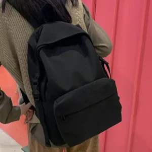 Black nylon water-resistant backpack for students shown in back-view lifestyle setting