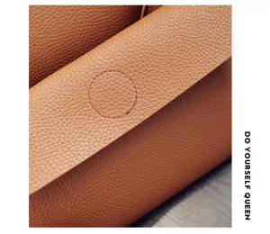 Nahaufnahme der braunen Litschi-Muster-Ledertaschentextur und feiner Nahtdetail.