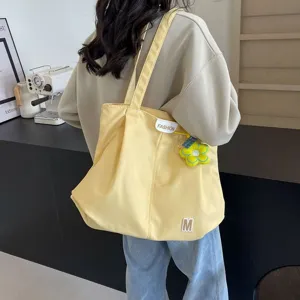 Vista detallada del bolso tote de lona amarilla informal para los desplazamientos diarios.