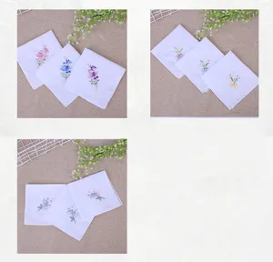 Gros plan des détails de mouchoirs pour femmes en coton blanc avec broderie florale délicate.