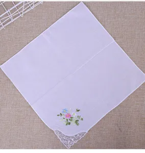 Mouchoir en coton blanc pour femme avec broderie florale et coin en dentelle fine.