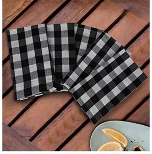 Macro view of black and white buffalo plaid kitchen tea towels on a wooden surface