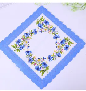 Close-up of cotton floral handkerchief with blue scalloped crescent edges and lilies