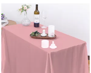 Vista detallada del mantel rectangular de satén rosa dispuesto en una mesa con decoraciones.
