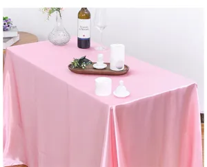 Vista detallada de un mantel de satén rosa en una elegante decoración de mesa.