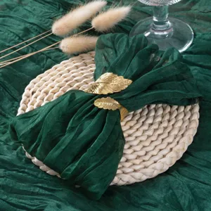 Set de serviette en gaze froissée verte et rond de serviette feuille d'or pour déco de table.