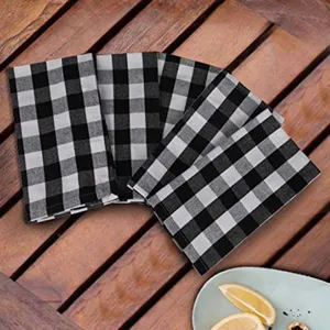Pack of 4 black and white buffalo check plaid kitchen tea towels on a rustic wooden table