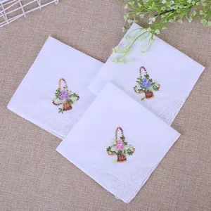 Mouchoir en coton blanc brodé de fleurs avec bordure en dentelle, design de panier floral.
