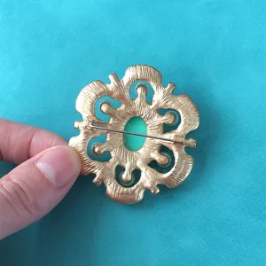Detail view showing the back pin mechanism of the vintage gold baroque floral brooch