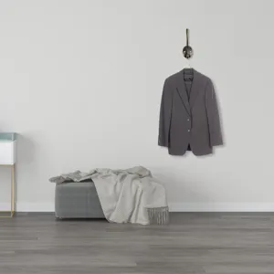 European retro bronze metal coat hook mounted on a white wall with a grey suit jacket hanging