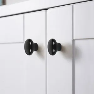 Close-up van een glanzende zwarte keramische meubelknop, minimalistische handgreep.