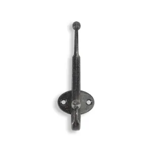 Macro detail view of a vintage iron coat hook with a rustic matte black textured finish