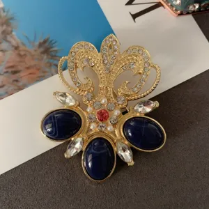 Close-up detail of a vintage gold Baroque brooch with navy blue stones and rhinestones