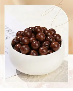Close-up macro shot of polished sandalwood round beads in a elegant white ceramic bowl