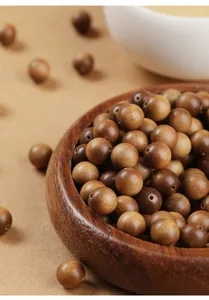 Close-up detail of natural sandalwood beads showing fine wood grain and drill holes