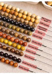 Close-up of various wooden loose beads including ebony, sandalwood, and wenge textures.