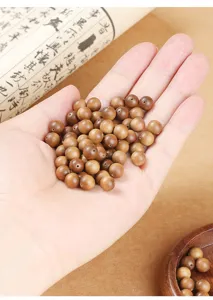 Close-up view of premium loose sandalwood beads held in hand for DIY bracelet making