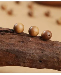 Macro view of three natural sandalwood beads with fine grain on rustic wood bark