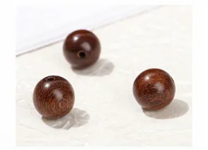 Close-up of golden silk sandalwood round beads showing natural wood grain texture