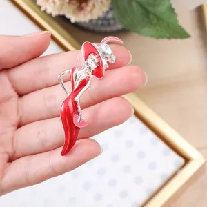 Detail view of an elegant lady brooch featuring red enamel dress and sparkling faux crystal hat.