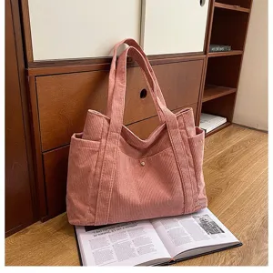 Vista dettagliata di una borsa tote in velluto a coste rosa in una stanza accogliente