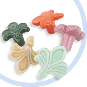 Gros plan de boutons de meubles en céramique en forme de feuille d'érable colorée