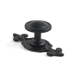Macro detail of a vintage European style matte black zinc alloy furniture drawer knob handle