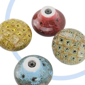 Detailed view of colorful ceramic cabinet knobs showing pattern and metal screw holes.