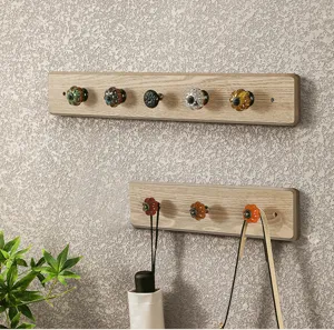 Vue détaillée de patères murales rétro en bois avec boutons en céramique vintage.